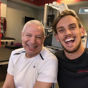 Trainer Caleb and training client, Massimo (with Spinal Dural Arteriovenous Fistula) feeling excited after a very successful workout session practicing independent balancing and core strengthening!